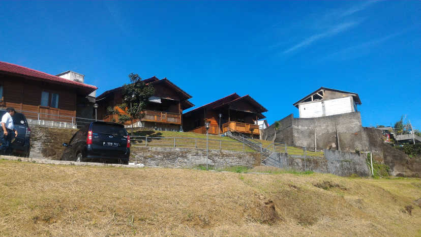 Cars parking on the cliff in front of wooden house
