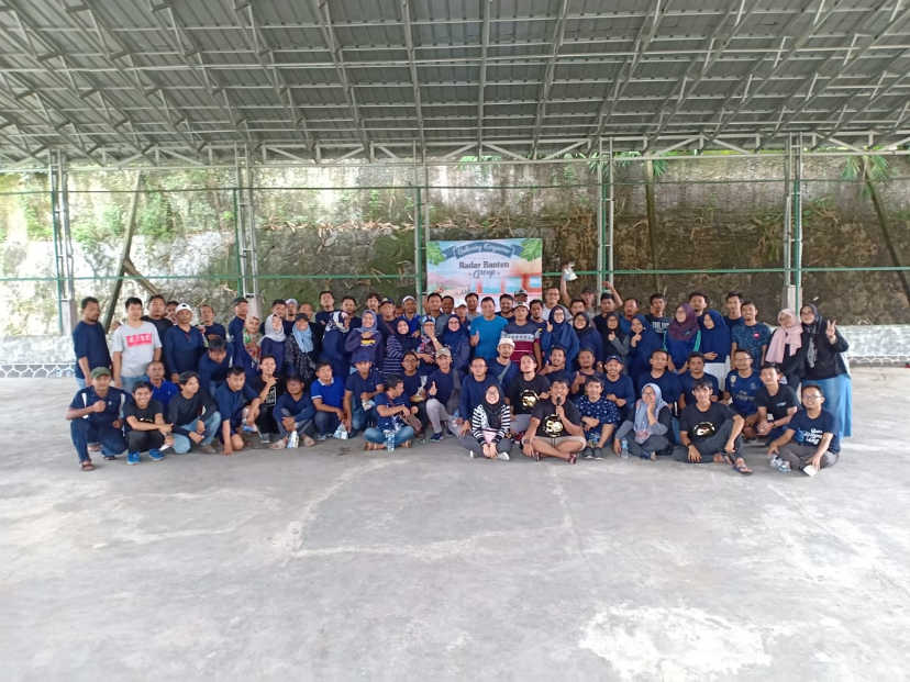 Foto bersama siswa dengan kaos biru di dalam aula serbaguna