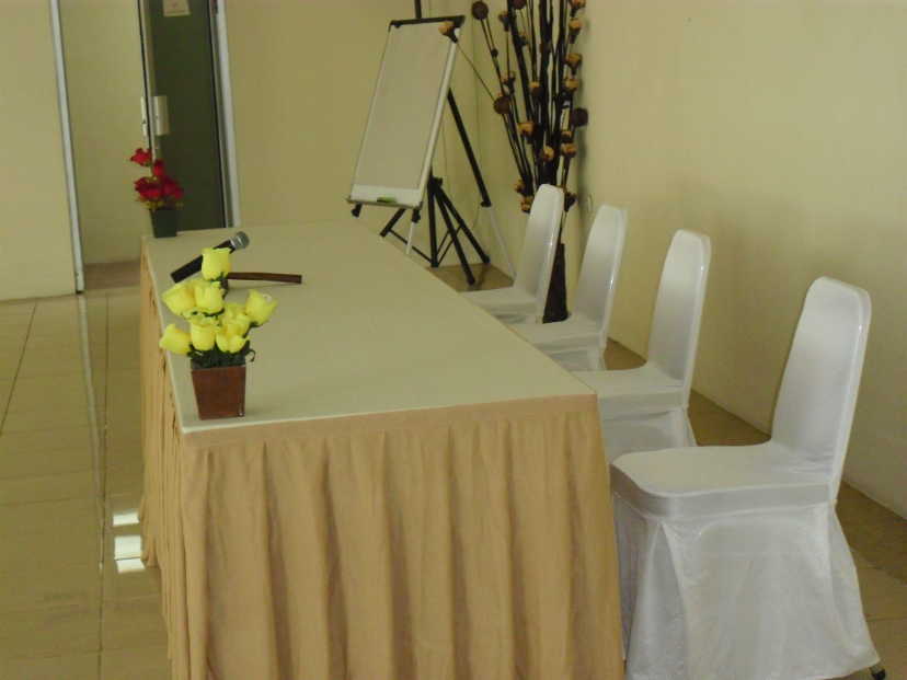 Meja dibungkus kain dengan bunga untuk pembicara tamu di Meeting Room